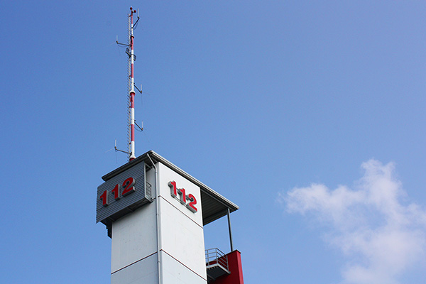 einen Turm mit einem Antennenmast und den großen Ziffern 112.